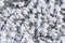 Snowy white background with frosty crystals and curly snowflakes close-up. Winter is a cold season with a blinding white bright