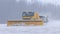 Snowy winter at the airport - a big snowplow removes snow from the path on the way