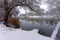 Snowy winter landscape with tranquil river or lake