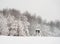 Snowy winter mountain forest scape with a deer stand