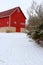 Snowy winter rural landscape with red barn