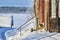 Snowy winter in Russian village, three cats are sitting on porch of wooden house.