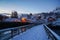 Snowy wooden bridge in Lofoten Islands and red wooden house in morning sunlight backdrop in winter