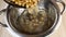 Soaked chickpeas are poured into colander to drain water. Close-up top view, cooking healthy food