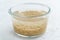 Soaking brown rice cereal in water to ferment cereals and neutralize phytic acid. Large glass bowl with grains flooded with water