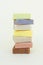 Soap bars stack made with natural herbal ingredients and scented essential oils over light yellow background