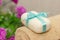 Soap with blue ribbin bow on towel and witn purple flowers on th