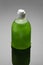 Soap bottle on grey background with shadow. Green color dishwashing liquid