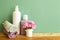 Soap bottles and towel with flowers on wooden shelf