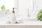 Soap dispenser with shampoo and towel on defocused bathroom background