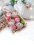 Soap floweres in box, knitted clothing, rose and lights on white background.