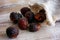 Soap nuts spilling from bag on wooden background.