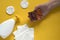 Soap in a womanâ€™s hand, plastic dispenser bottle of liquid soap, cotton pads and paper wipes on yellow background