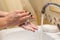 Soaping hands, fingers with soap while washing hands, female arms
