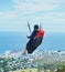 Soar high and the world will be at your feet. a man paragliding on a sunny day.