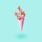 Soaring Painted pink ice cream cone with christmas tree and golden balls. Minimal holiday concept. Modern greeting card