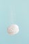 Soaring white zephyr marshmallow on blue background with sugar powder flying food levitation