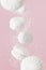 Soaring white zephyr marshmallow on pink background with sugar powder flying food levitation