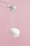 Soaring white zephyr marshmallow on pink background with sugar powder flying food levitation