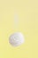 Soaring white zephyr marshmallow on yellow background with sugar powder flying food levitation