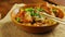 Soba with chicken and vegetables in teriyaki sauce in a wooden plate next to soy sauce and sesame sticks