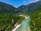 Soca Valley, Slovenia - Aerial view of the emerald alpine river Soca on a bright sunny summer day with Julian Alps, blue sky
