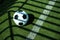 Soccer ball black and white on artificial ground ground with shadows stripes, over the line