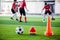 Soccer ball and cone marker on green artificial turf with blurry of soccer player training