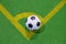 Soccer ball on a corner kick line on an artificial green grass top view