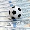 Soccer ball on dollar banknotes, closeup. Betting on sport concept. Square picture frame. Football corruption game.