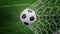 Soccer ball on goal with net and green background