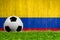 Soccer ball on grass with Colombia flag background