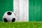 Soccer ball on grass with Nigeria flag background