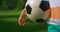 Soccer ball in hand young sportsman in park close up. Unknown boy holding ball.