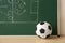 Soccer ball near chalkboard with football game scheme