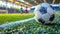 Soccer ball on an outdoor field with blurry players in the background.