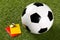 Soccer ball with referee yellow and red cards and chrome whistle on grass background - penalty, foul or sports concept