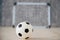 A soccer ball in a small gate on a gray background. Mini football.