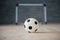 A soccer ball in a small gate on a gray background. Mini football.