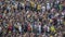 Soccer fans watch the football match. Big crowd of people on the stadium.