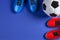 Soccer football background. Top view of soccer ball and two pair of soccer football sports shoes on blue background