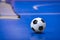 Soccer Football Ball on Futsal Field. Blue Futsal Training Pitch. Training Agility Ladder in the Background