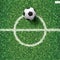 Soccer football ball on green grass of soccer field with center line area. Vector