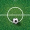 Soccer football ball on green grass of soccer field with center line area. Vector