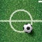 Soccer football ball on green grass of soccer field with center line area. Vector