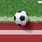 Soccer football ball on green grass of soccer field with running track for sports background. Vector