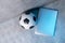 Soccer and football ball and grey laptop on grey background. Online workout concept