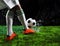 Soccer football players kicking to soccer ball on green grass field with splashing of transparent water against black background