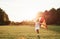 Soccer gates behind. Happy girl in white clothes have fun with kite in the field. Beautiful nature