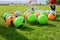 Soccer gears on green grass prepared for training in kids football academy. Popular sport activity